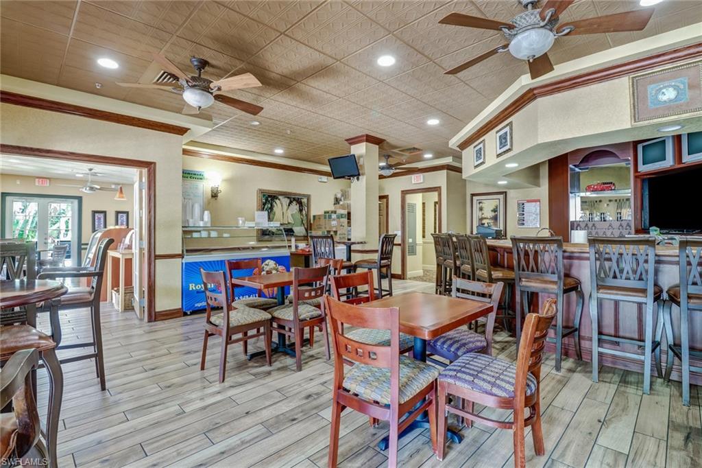 20121 Estero Gardens Circle, Unit 203 Estero, FL 33928 - Photo 27 of 40 a view of a dining room with furniture wooden floor and chandelier