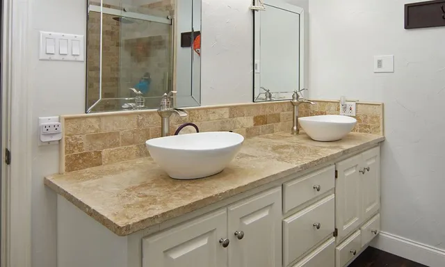 a bathroom with a granite countertop sink and a mirror
