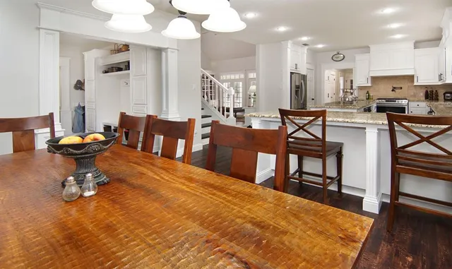 a living room with couches chairs and kitchen view with wooden floor