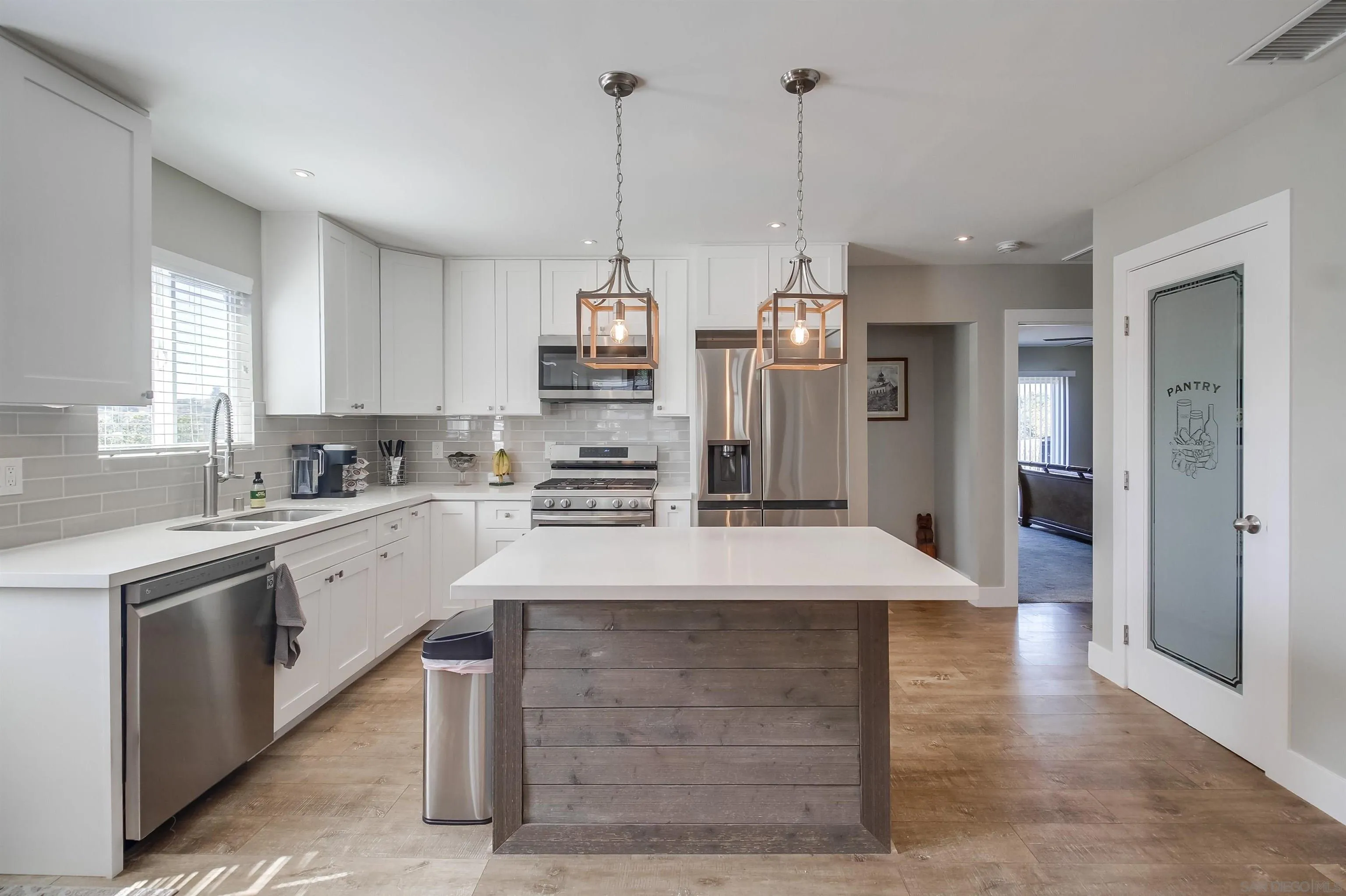 a kitchen with kitchen island a sink stainless steel appliances and cabinets