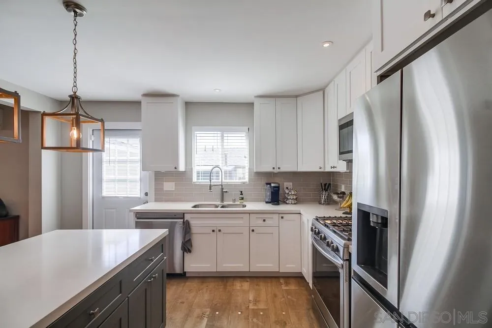 730 Pidgeon Street San Diego, CA 92114 - Photo 12 of 39 a kitchen with a sink a refrigerator a stove and white cabinets