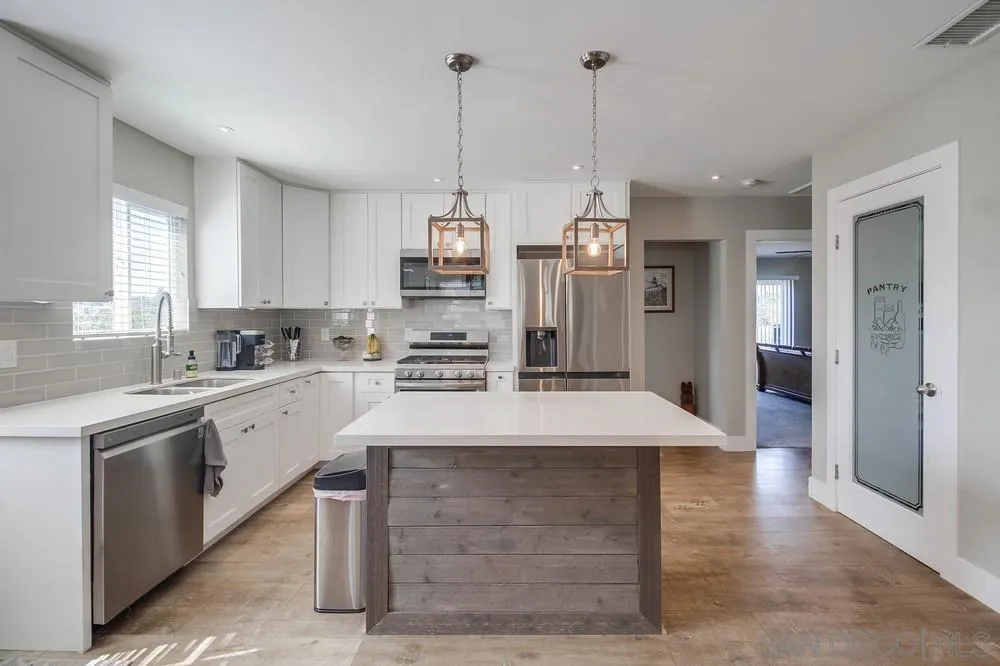 730 Pidgeon Street San Diego, CA 92114 - Photo 9 of 39 a kitchen with kitchen island a sink stainless steel appliances and cabinets