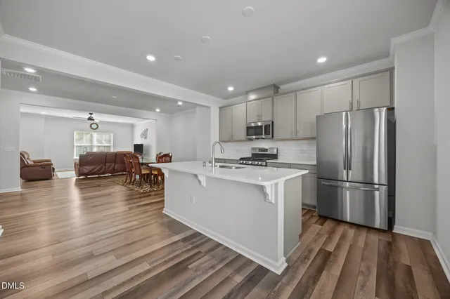 a kitchen with sink a refrigerator and wooden floor
