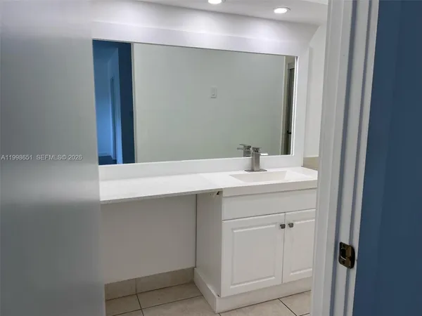 a bathroom with a sink vanity and a mirror