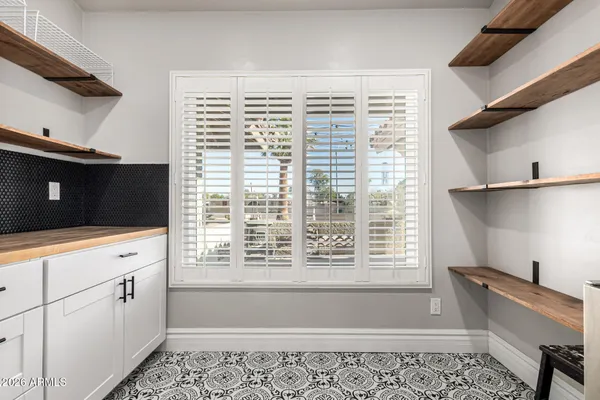 a kitchen with white cabinets and a window