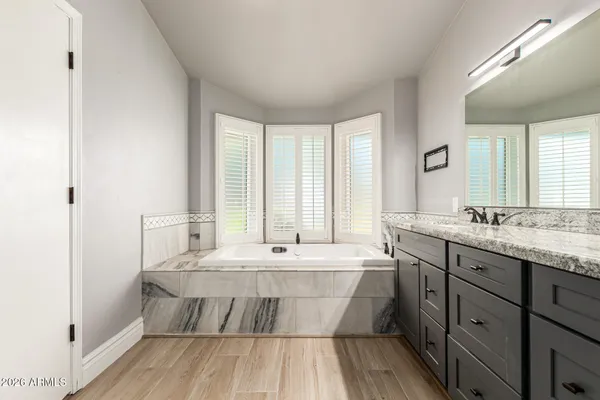 a bathroom with a granite countertop shower sink vanity and mirror