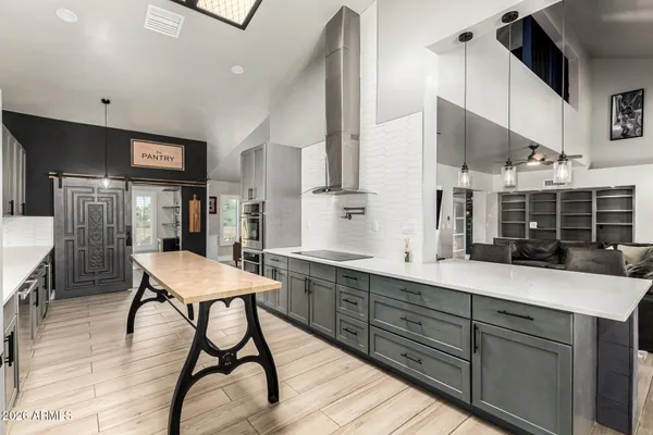 a kitchen with stainless steel appliances kitchen island hardwood floor and sink