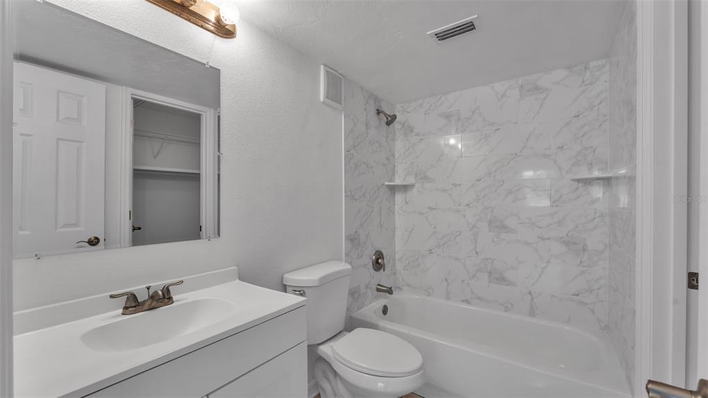 141 Fernery Road, Unit D1 Lakeland, FL 33809 - Photo 14 of 29 a bathroom with a bathtub shower sink vanity mirror and toilet
