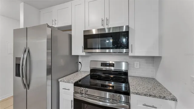 a kitchen with stainless steel appliances granite countertop a refrigerator stove and microwave