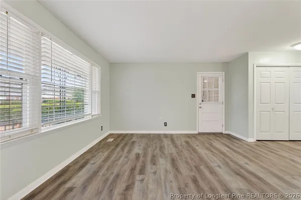 a view of a room with wooden floor and windows