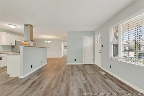 a view of empty room with wooden floor