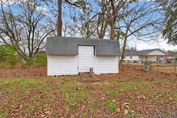 a view of house with backyard and trees
