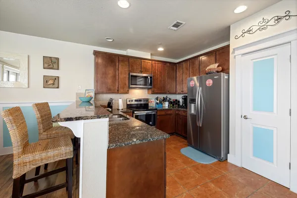 a kitchen with granite countertop stainless steel appliances window a sink and cabinets