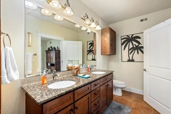 a bathroom with a granite countertop sink a large mirror and a shower