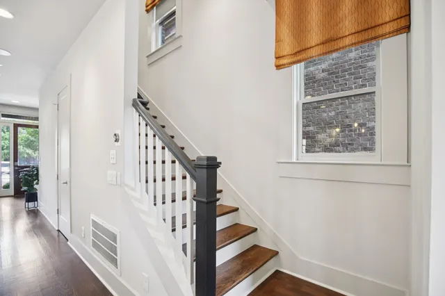 a view of an empty room with wooden floor and closet