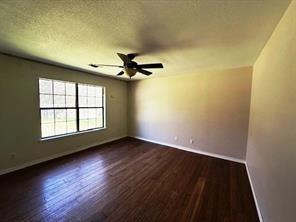 426 Gun Club Road Denison, TX 75021 - Photo 10 of 20 an empty room with wooden floor fan and windows