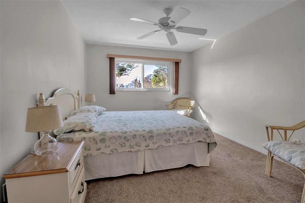 5420 Swift Road, Unit 38 Sarasota, FL 34231 - Photo 26 of 37 a bedroom with a bed and a chandelier