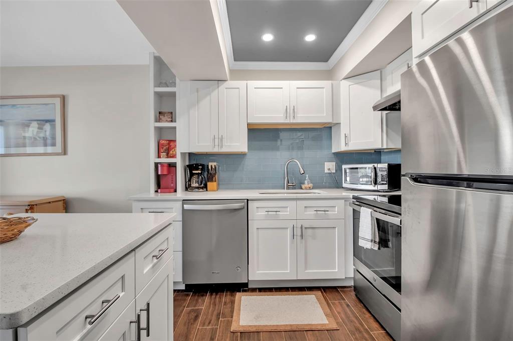5420 Swift Road, Unit 38 Sarasota, FL 34231 - Photo 10 of 37 a kitchen with white cabinets and stainless steel appliances