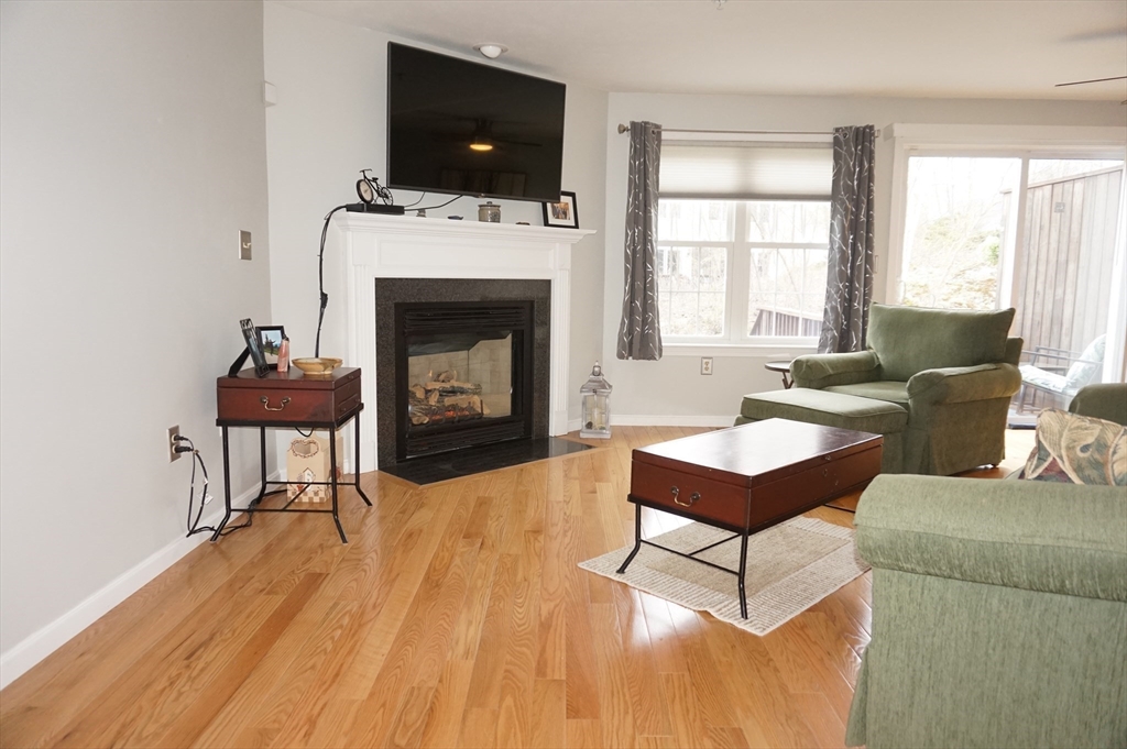 103 Bridle Cross Road, Unit 103 Fitchburg, MA 01420 - Photo 14 of 36 a living room with furniture a fireplace and flat screen tv