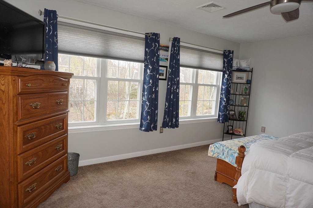 103 Bridle Cross Road, Unit 103 Fitchburg, MA 01420 - Photo 24 of 36 a bedroom with a bed and flat tv screen on the dresser