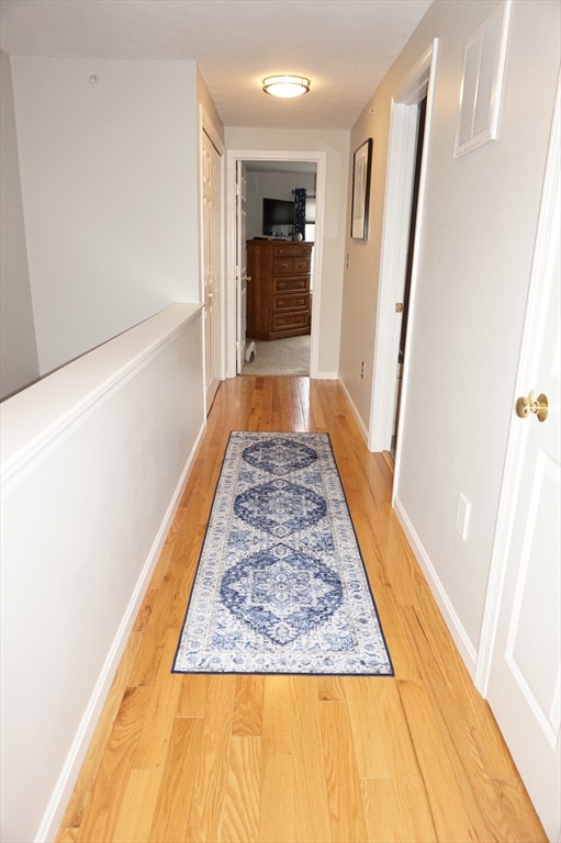 103 Bridle Cross Road, Unit 103 Fitchburg, MA 01420 - Photo 29 of 36 view of a hallway with wooden floor and cabinet
