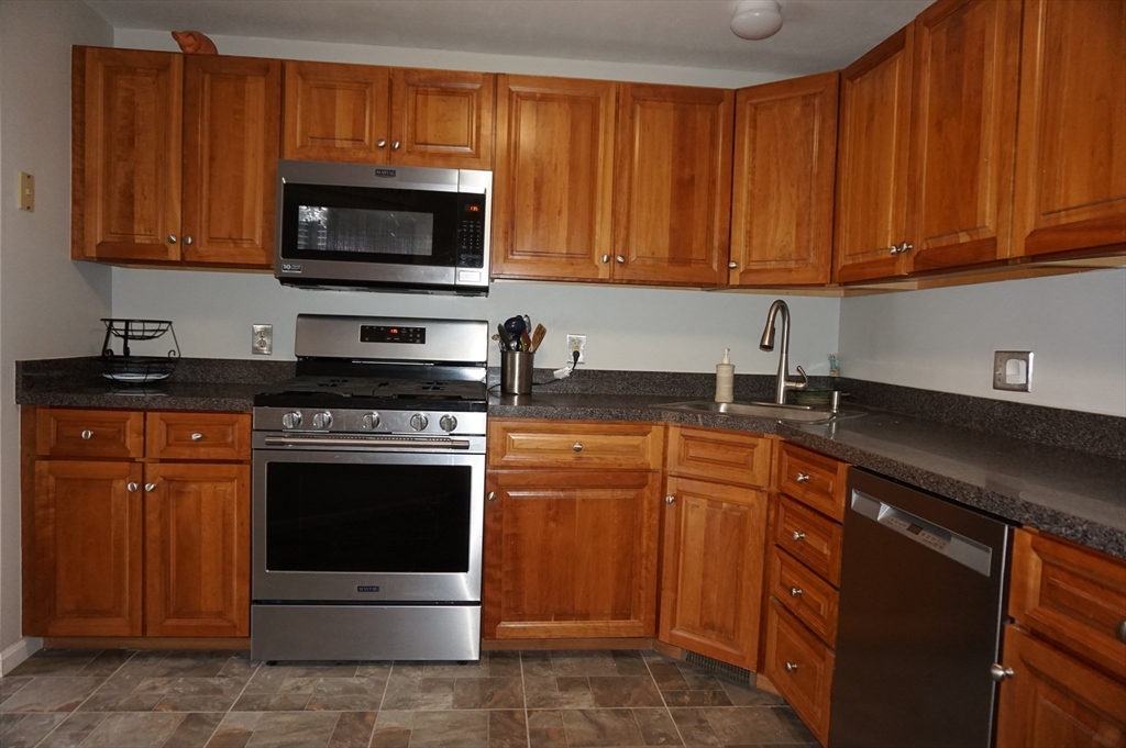 103 Bridle Cross Road, Unit 103 Fitchburg, MA 01420 - Photo 7 of 36 a kitchen with stainless steel appliances granite countertop a stove microwave and sink