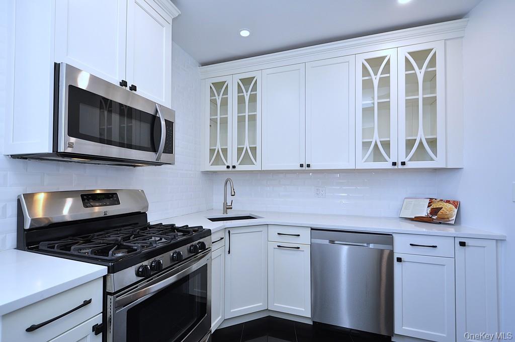 949 Palmer Road, Unit 2G Bronxville, NY 10708 - Photo 7 of 40 a kitchen with stainless steel appliances granite countertop a stove and a microwave