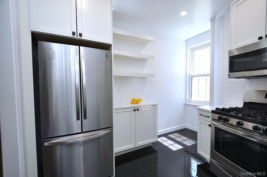 949 Palmer Road, Unit 2G Bronxville, NY 10708 - Photo 8 of 40 a kitchen with stainless steel appliances a refrigerator stove and microwave