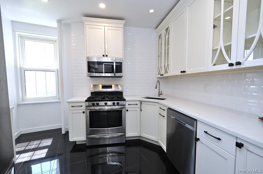 949 Palmer Road, Unit 2G Bronxville, NY 10708 - Photo 9 of 40 a kitchen with stainless steel appliances a stove and white cabinets