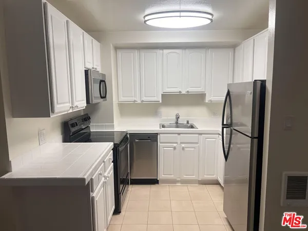 a kitchen with a refrigerator sink and stove