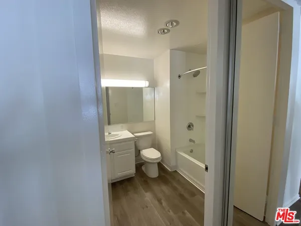 a bathroom with a granite countertop toilet a sink and a mirror
