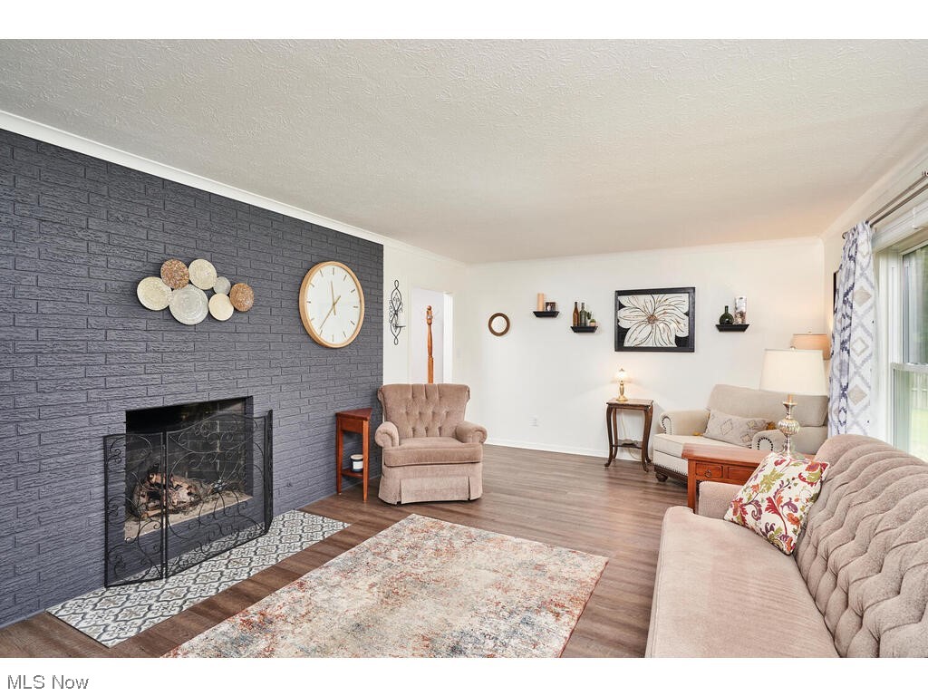 Living room featuring a textured ceiling, a fireplace, and luxury vinyl floors
