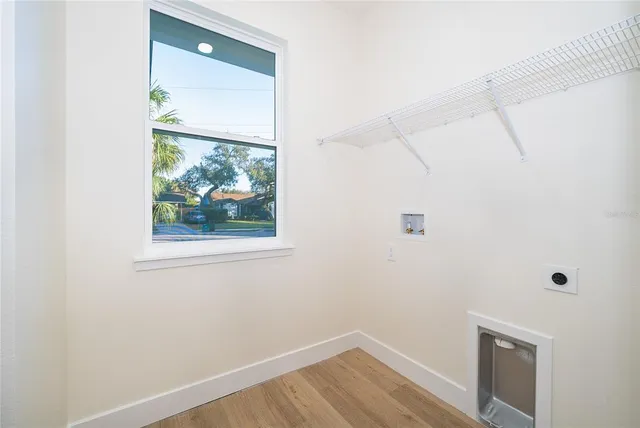 a view of a small space with wooden floor and a window