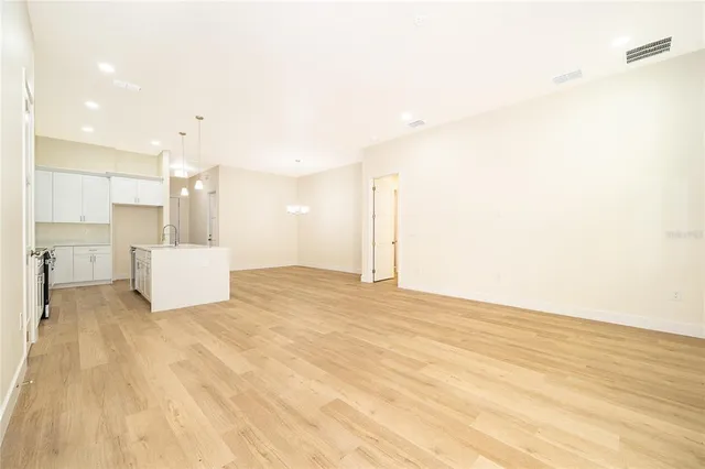 a view of a kitchen with white cabinets and wooden floor