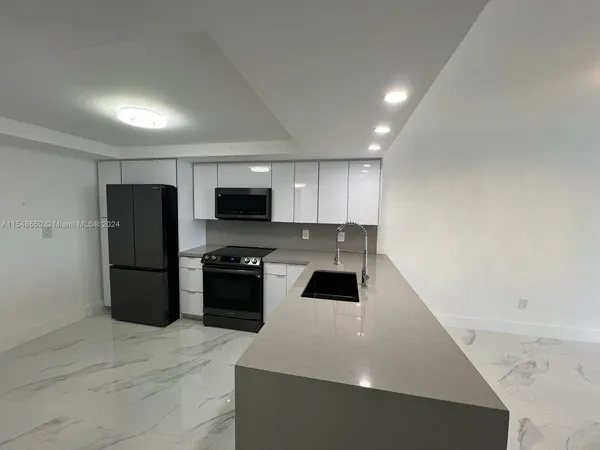 a kitchen with a refrigerator a stove top oven a sink and dishwasher