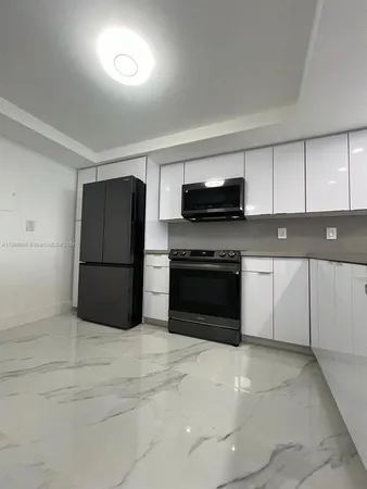 a kitchen with a sink a counter top space cabinets and stainless steel appliances