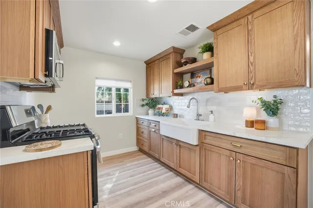 a kitchen with stainless steel appliances granite countertop a stove a sink and a refrigerator