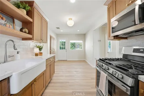 a kitchen with a refrigerator and white cabinets