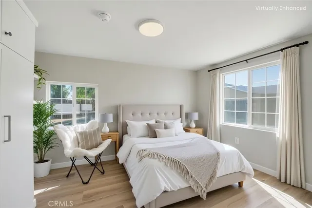 a view of a room with wooden floor lounge chair and windows