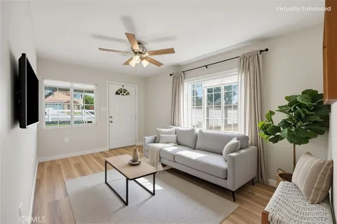 a view of a livingroom with furniture a ceiling fan and wooden floor