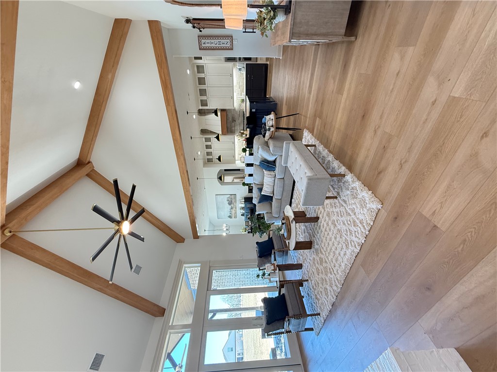 Living area with light wood-style flooring, ceiling fan, and recessed lighting
