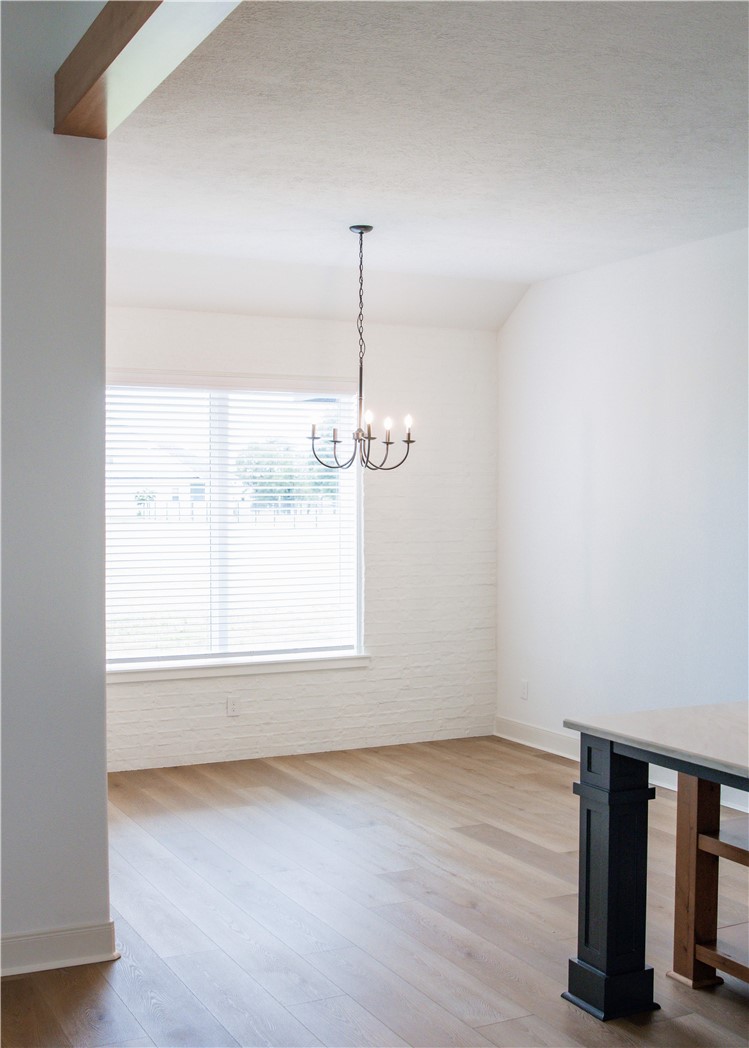 3201 Hunters Crossing Bryan, TX 77808 - Photo 10 of 40 Unfurnished dining area with light wood-type flooring and a chandelier