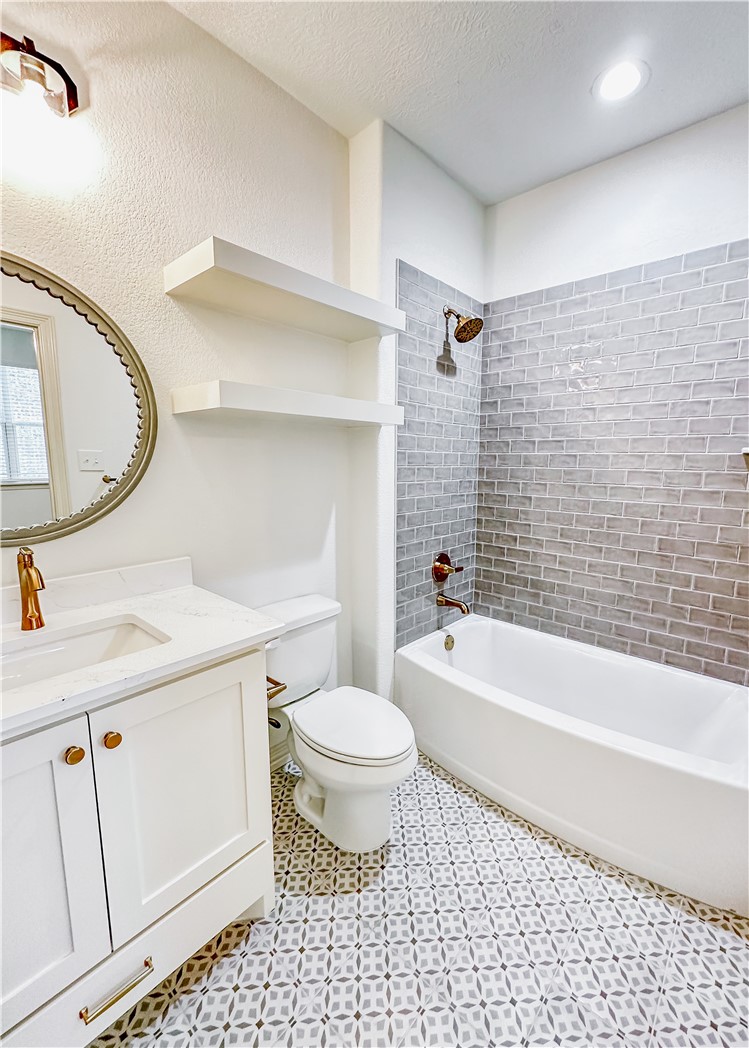 3201 Hunters Crossing Bryan, TX 77808 - Photo 19 of 40 Bathroom with shower / tub combination, vanity, a textured ceiling, and light tile patterned floors