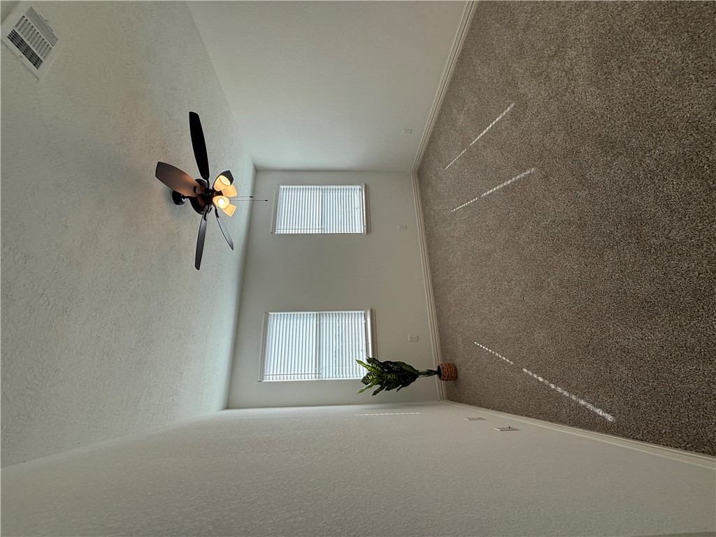3201 Hunters Crossing Bryan, TX 77808 - Photo 27 of 40 Carpeted empty room with plenty of natural light, a textured ceiling, and ceiling fan