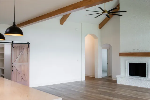 a view of a livingroom with wooden floor and a ceiling fan