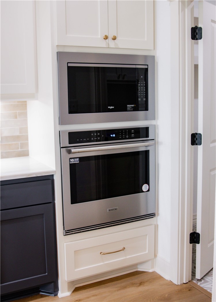 3201 Hunters Crossing Bryan, TX 77808 - Photo 8 of 40 Kitchen view of appliances with stainless steel finishes, white cabinets, light wood-style flooring, and decorative backsplash