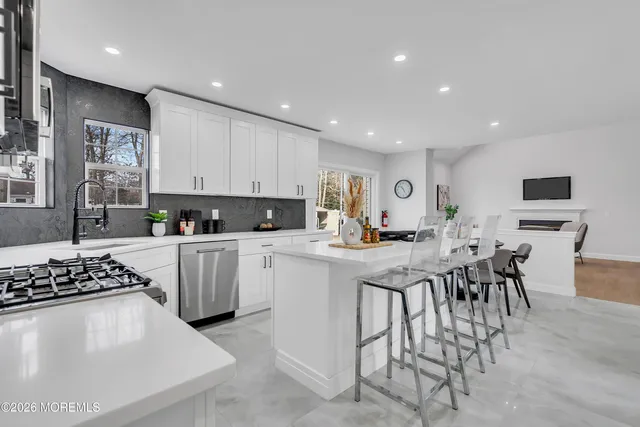 a kitchen with stainless steel appliances granite countertop a stove white cabinets a sink and dishwasher