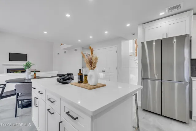 a kitchen with white cabinets and appliances