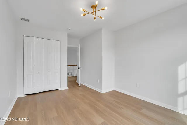a view of an empty room with a window and kitchen view