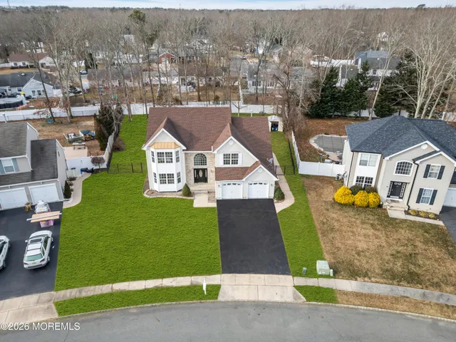 an aerial view of residential houses with outdoor space and parking